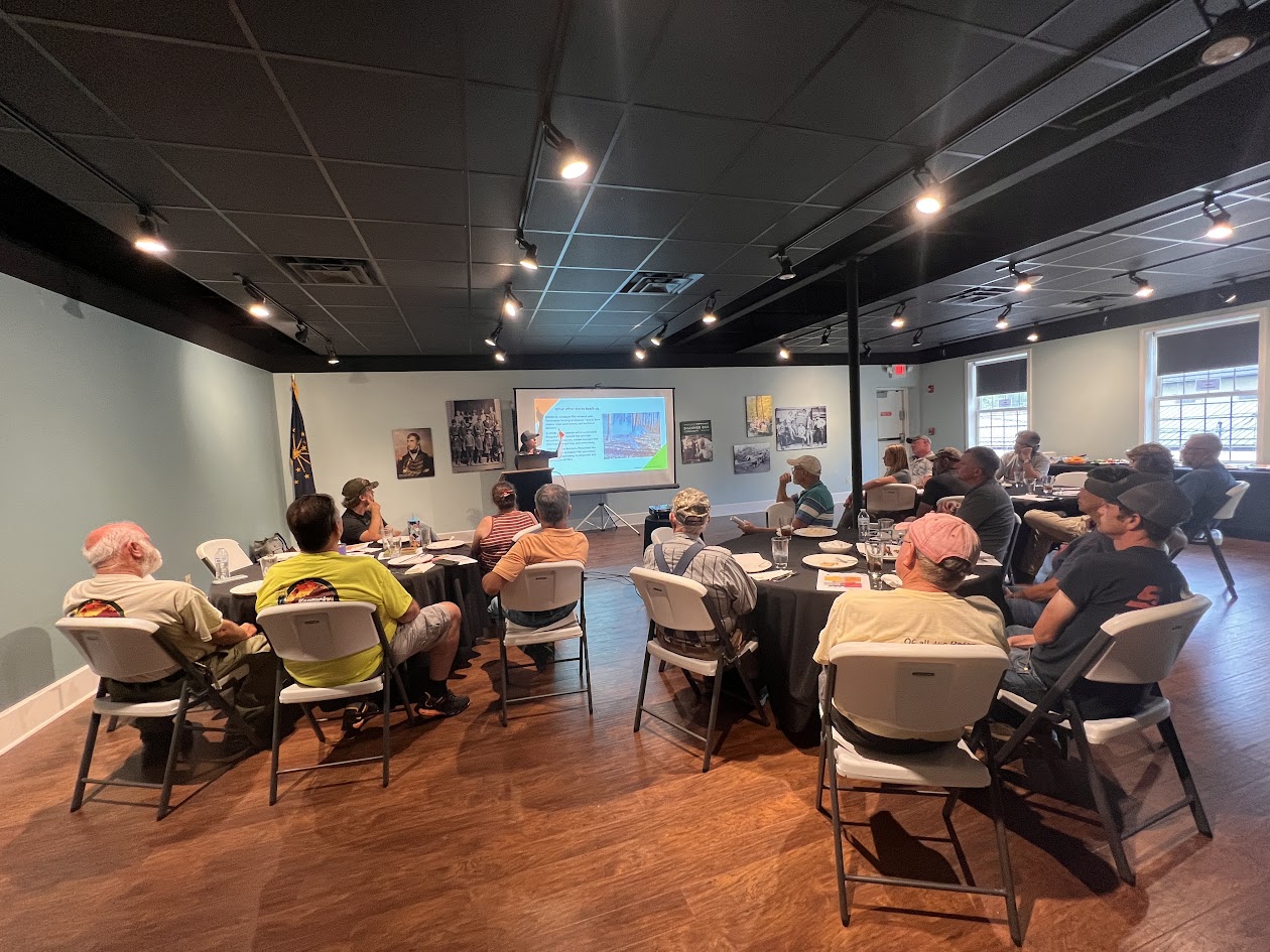 Group of people at round tables watching a presentation